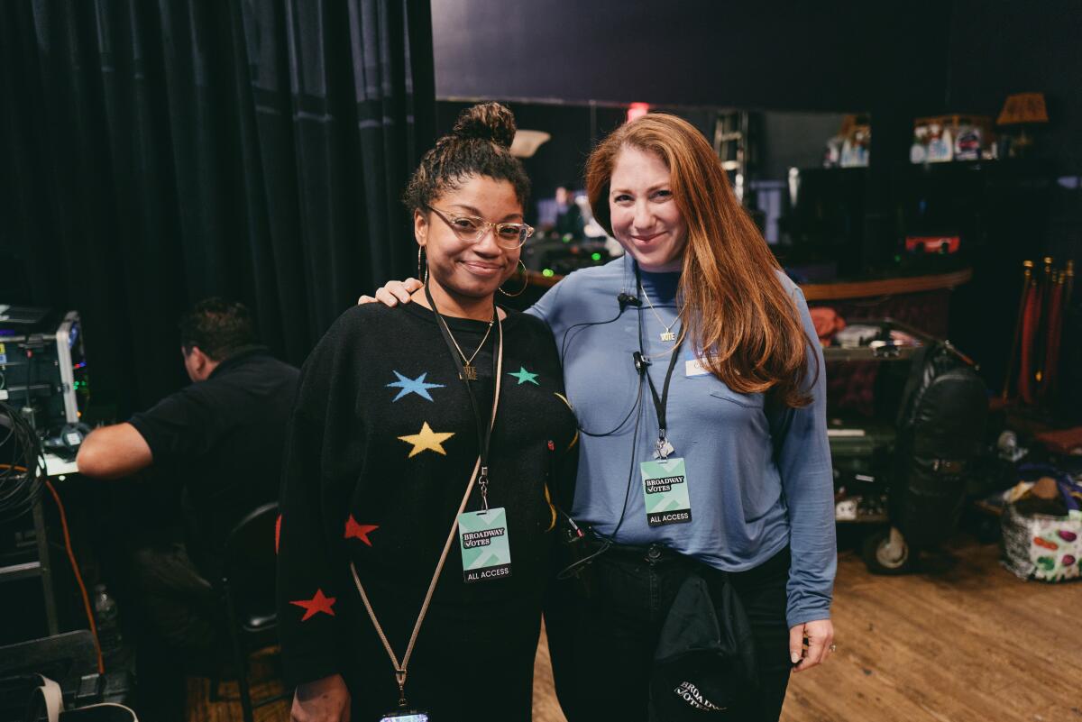 Two people stand together on a set.