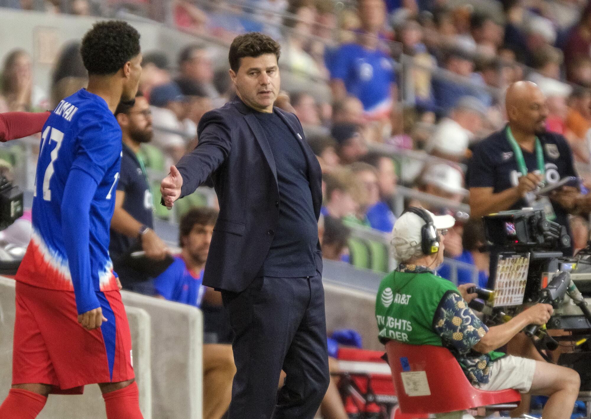 United States head coach, Mauricio Pochettino, calls over midfielder, Malik Tillman, (17) for a substitution.