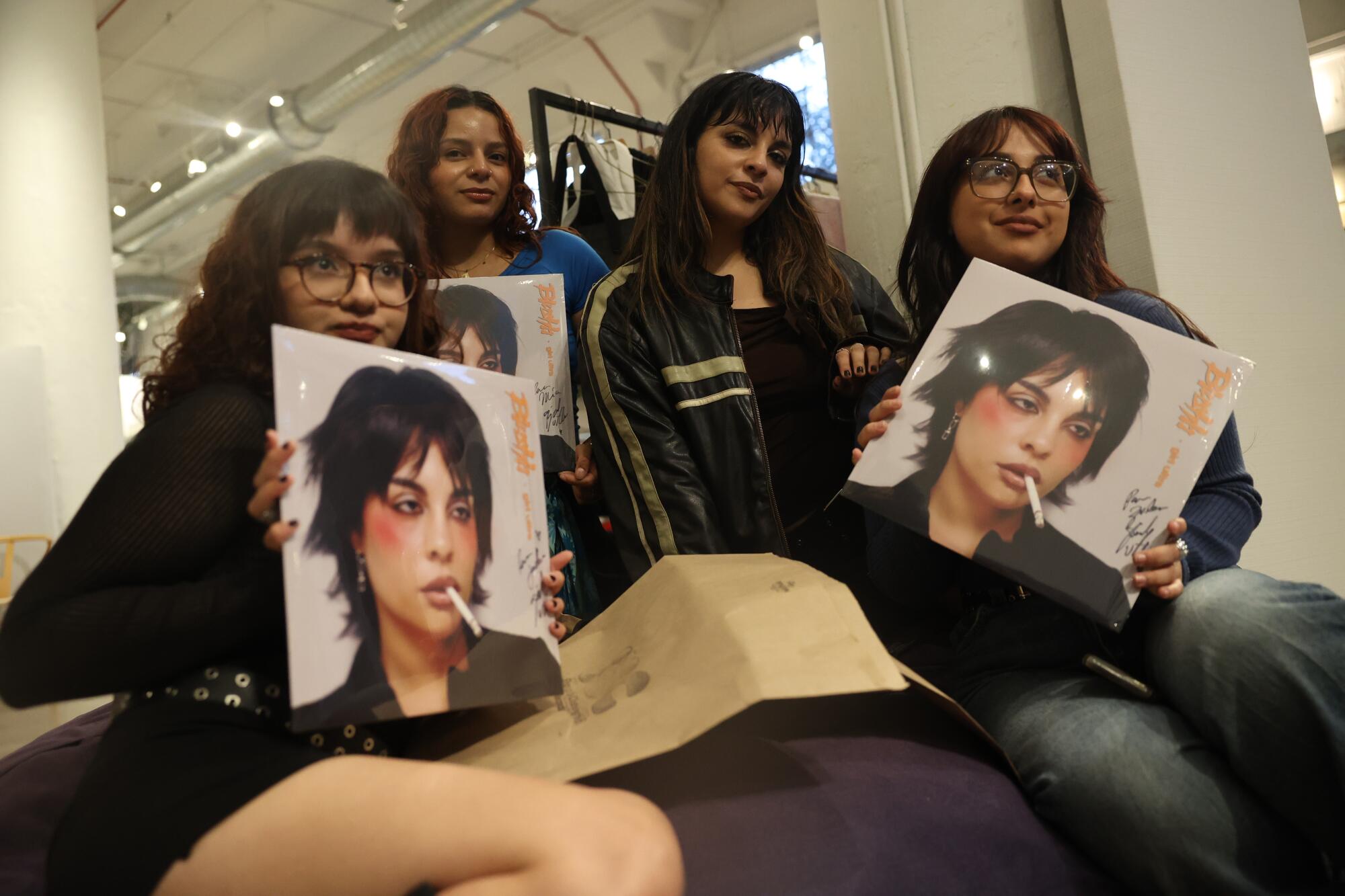 Mariana de Miguel poses for a photo with fans, in between signing vinyls.