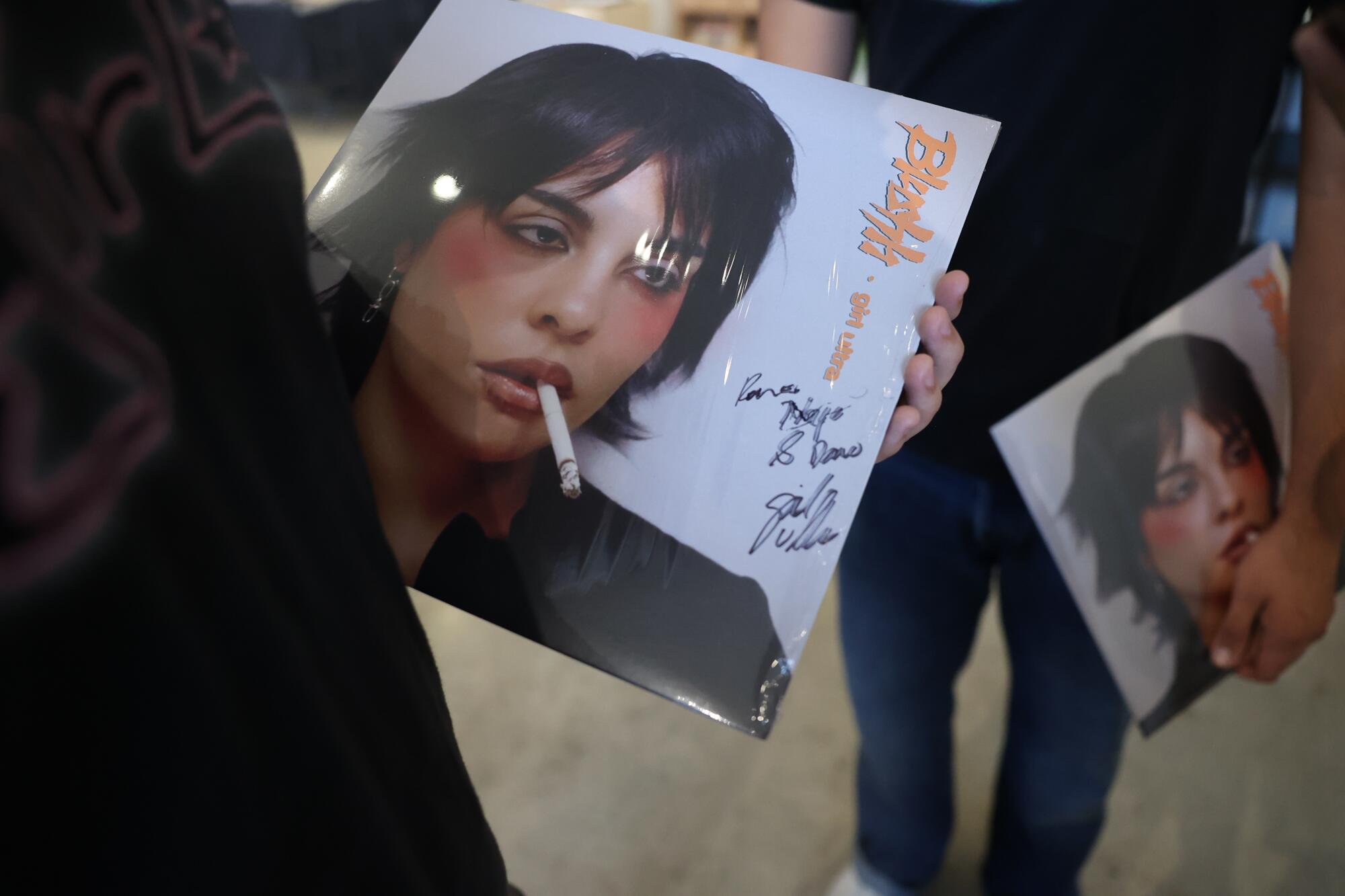 Fan holds signed vinyl records of Girl Ultra's new record "Blush."