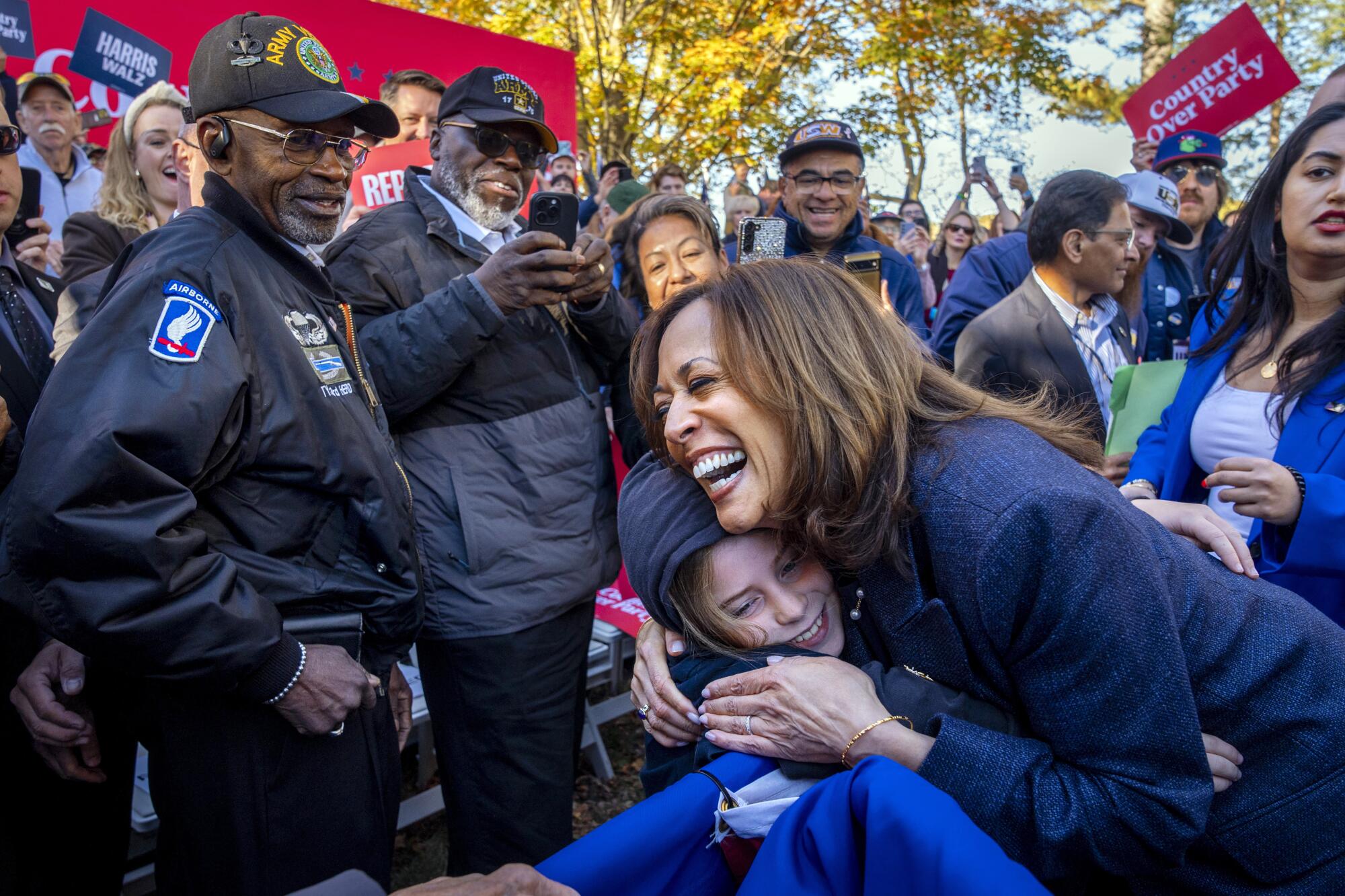 Democratic presidential nominee Vice President Kamala Harris hugs a child after speaking duri