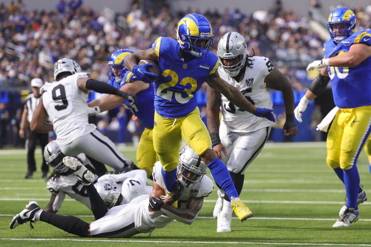 The Rams' Kyren Williams (23) runs for a touchdown as Las Vegas Raiders safety Isaiah Pola-Mao (bottom) attempts to tackle.