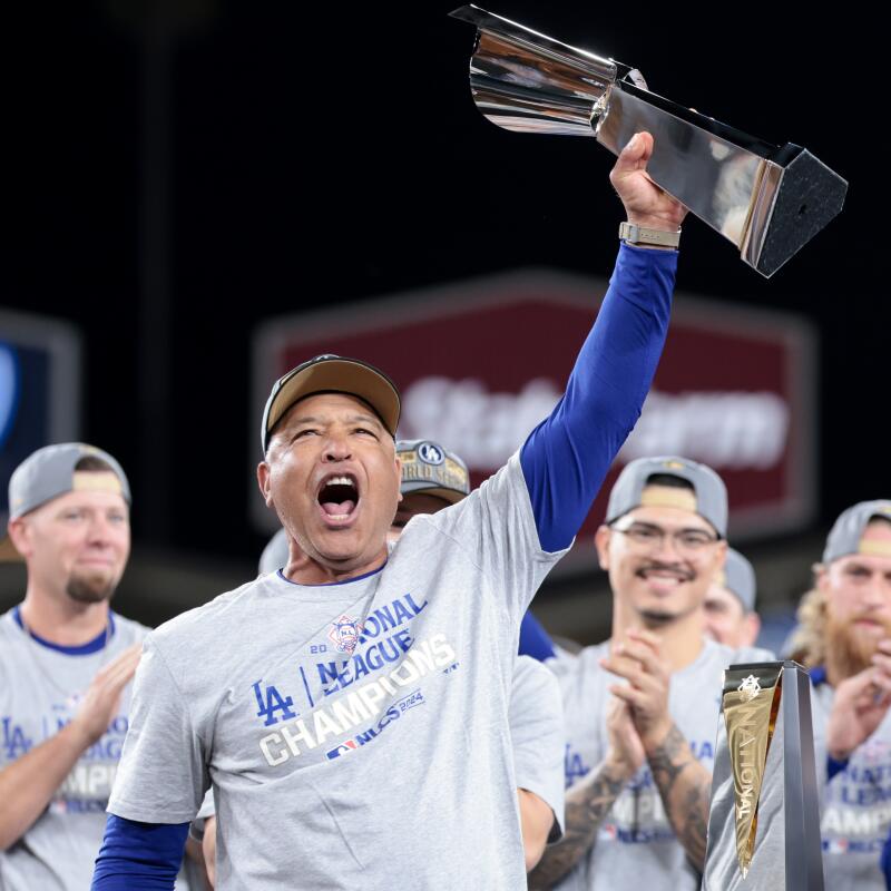 Dodgers manager Dave Roberts celebrates and holds up the Warren C. Giles Trophy, awarded to the winner of the National League Champions Series.