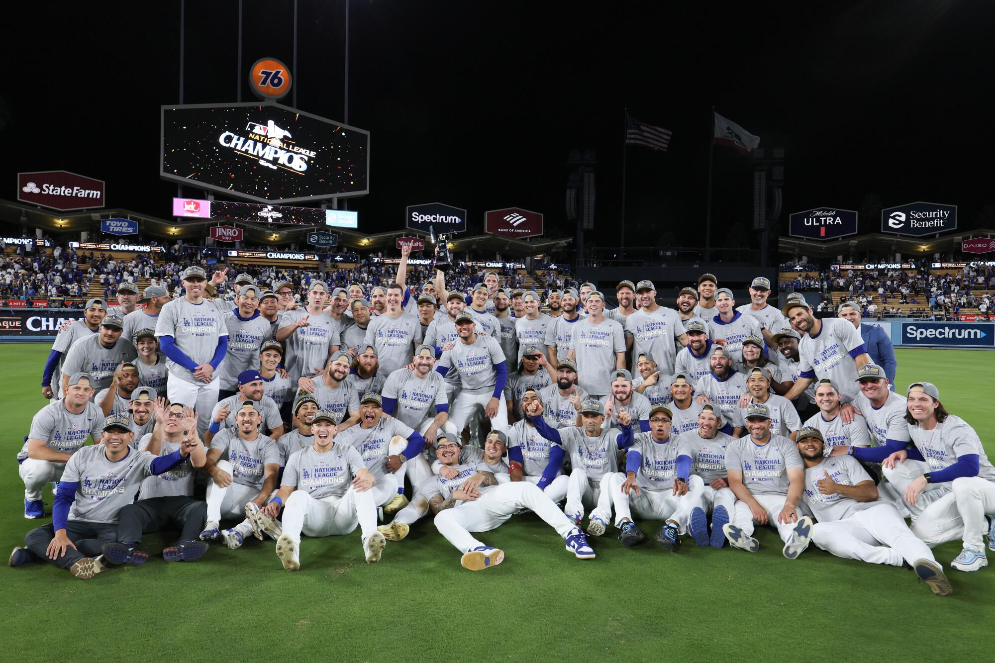 Dodgers players and coaches celebrate on the field after defeating the Mets in Game 6 of the NLCS