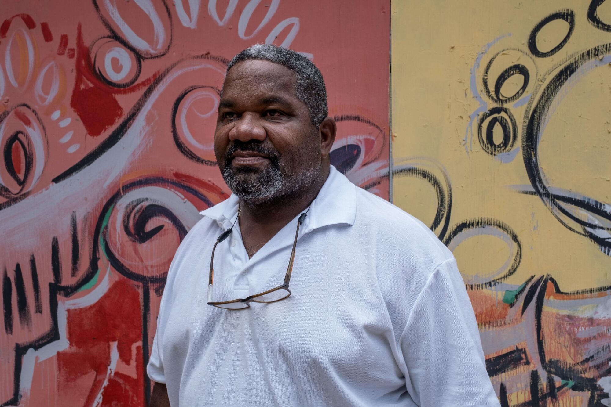 Rafael Rivera standing in front of a colorful mural