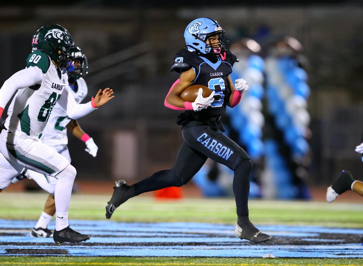 Carson High's Craig Walker tries to outrun Gardena defenders during a 23-7 win Friday night.