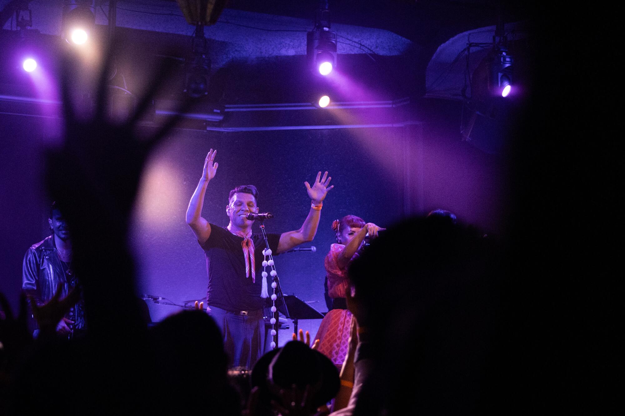 A performer raises his hands during a show.