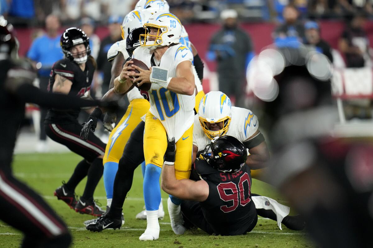 The Chargers' Justin Herbert (10) is sacked the Cardinals' Ben Stille (90).