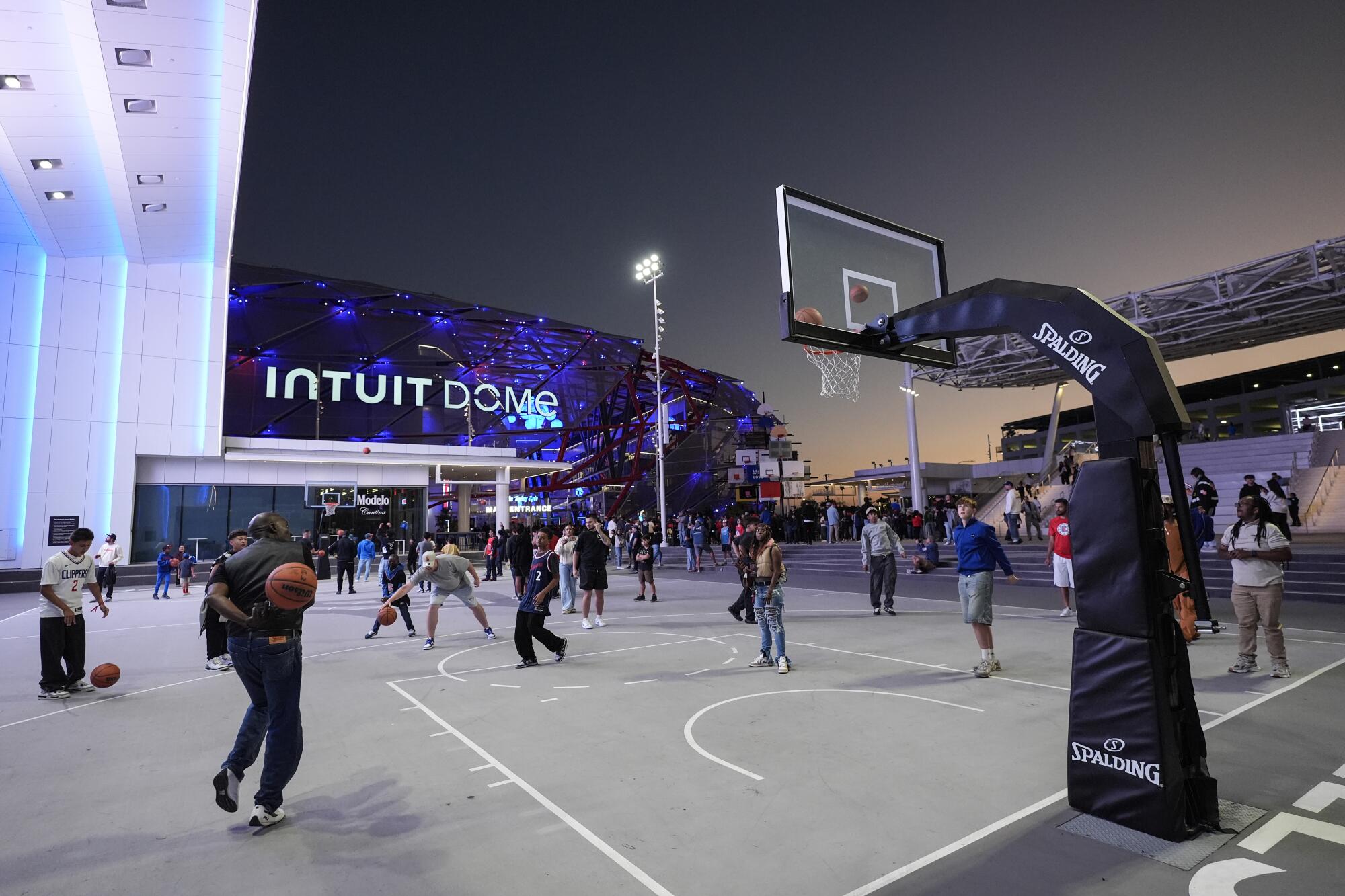 Fans play basketball outside the Intuit Dome, the Clippers' new home, before a preseason game 