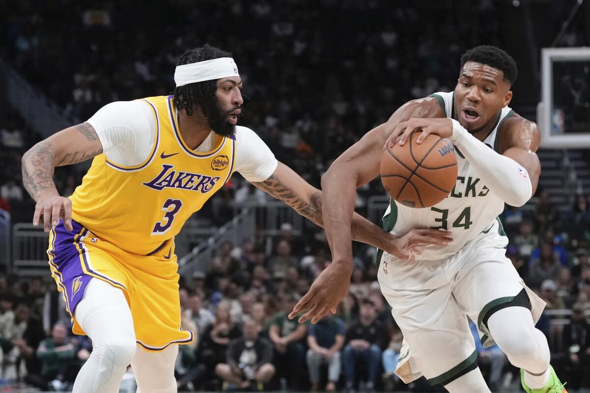 Lakers forward Anthony Davis hand-checks Milwaukee forward Giannis Antetokounmpo as he drives to the basket.