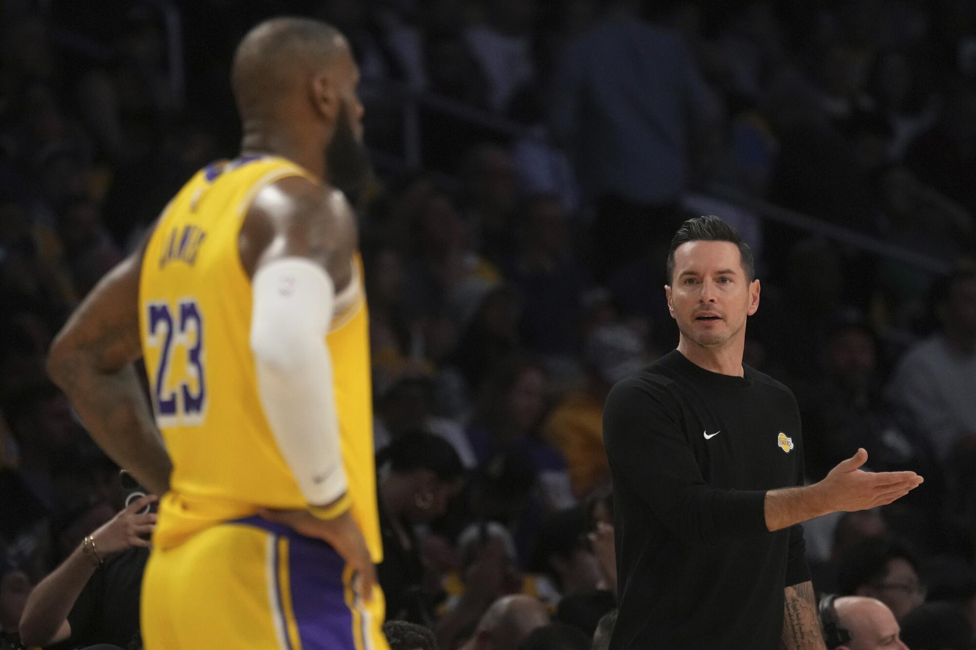 Lakers coach JJ Redick looks toward forward LeBron James during a game