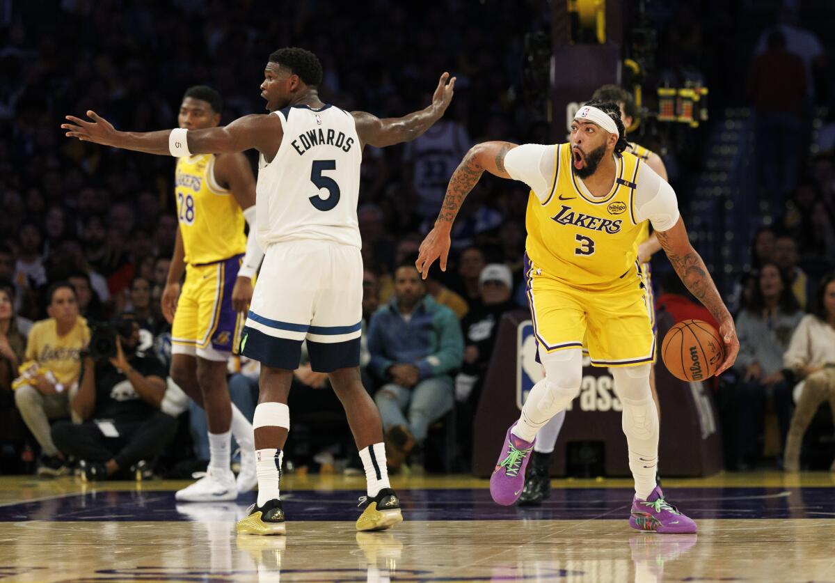 Lakers forward Anthony Davis, right, reacts after an official negates his steal from Timberwolves guard Anthony Edwards.