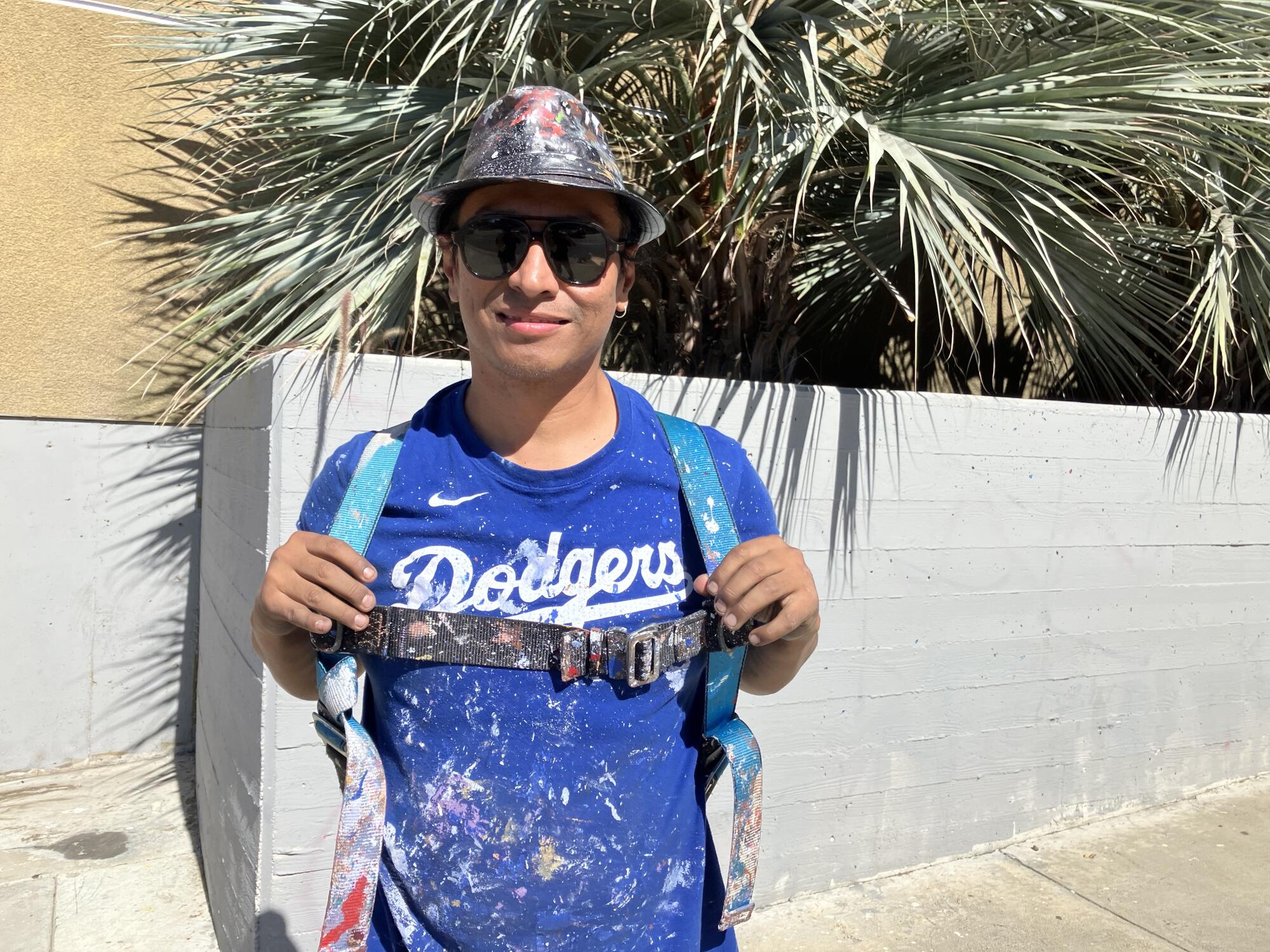 Artist Robert Vargas stands in front of the Boyle Heights building where he is painting a mural honoring Fernando Valenzuela.