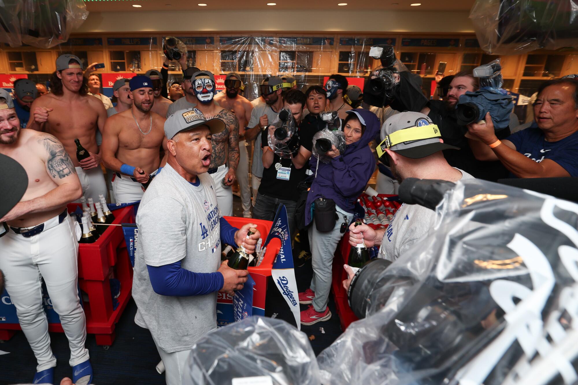 Dodgers manager Dave Roberts talks with his team as the Dodgers celebrate after defeating the Mets in the NLCS on Sunday.