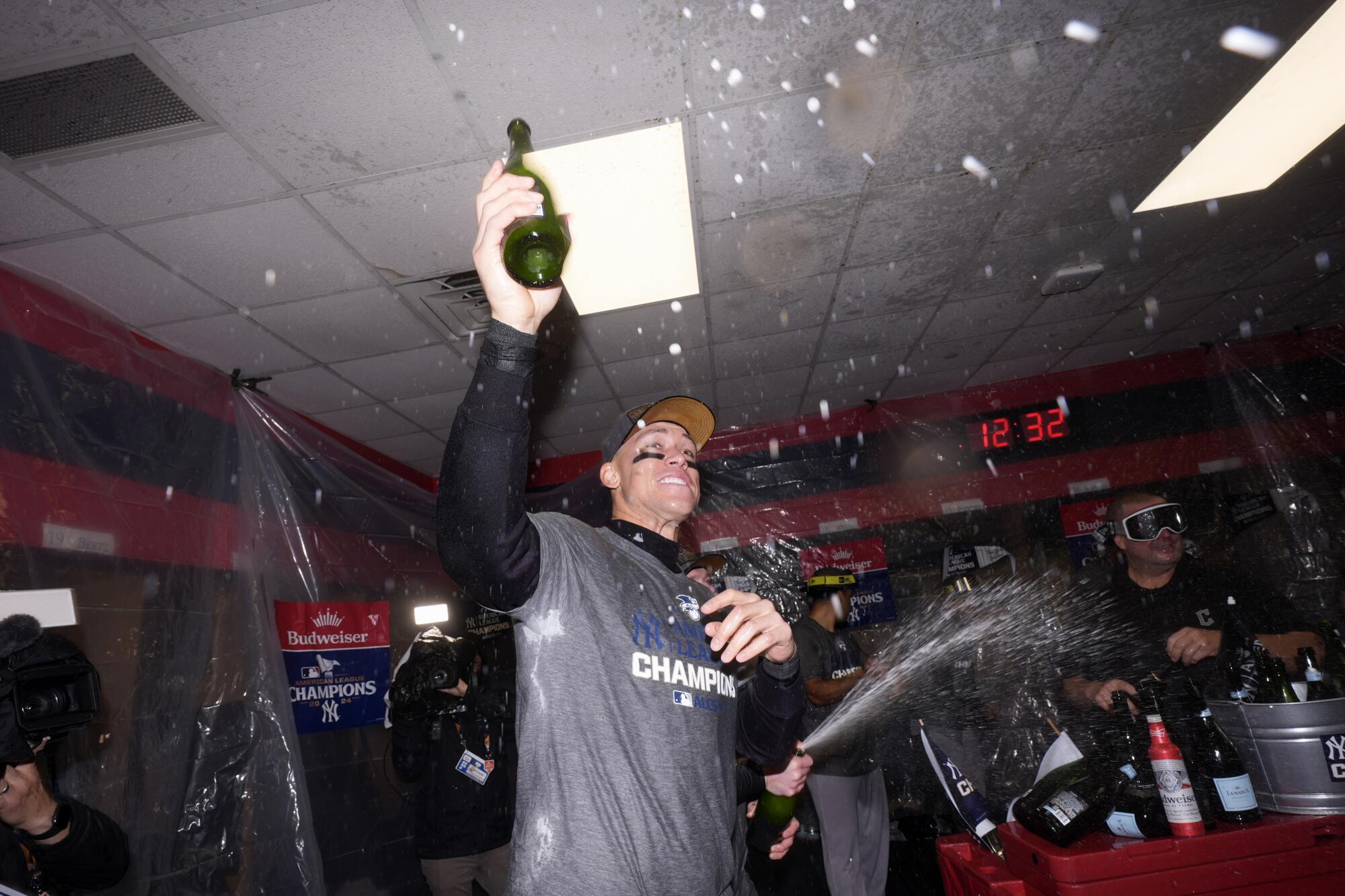 Yankee Aaron Judge holds up a bottle of Champagne to celebrate winning the pennant 