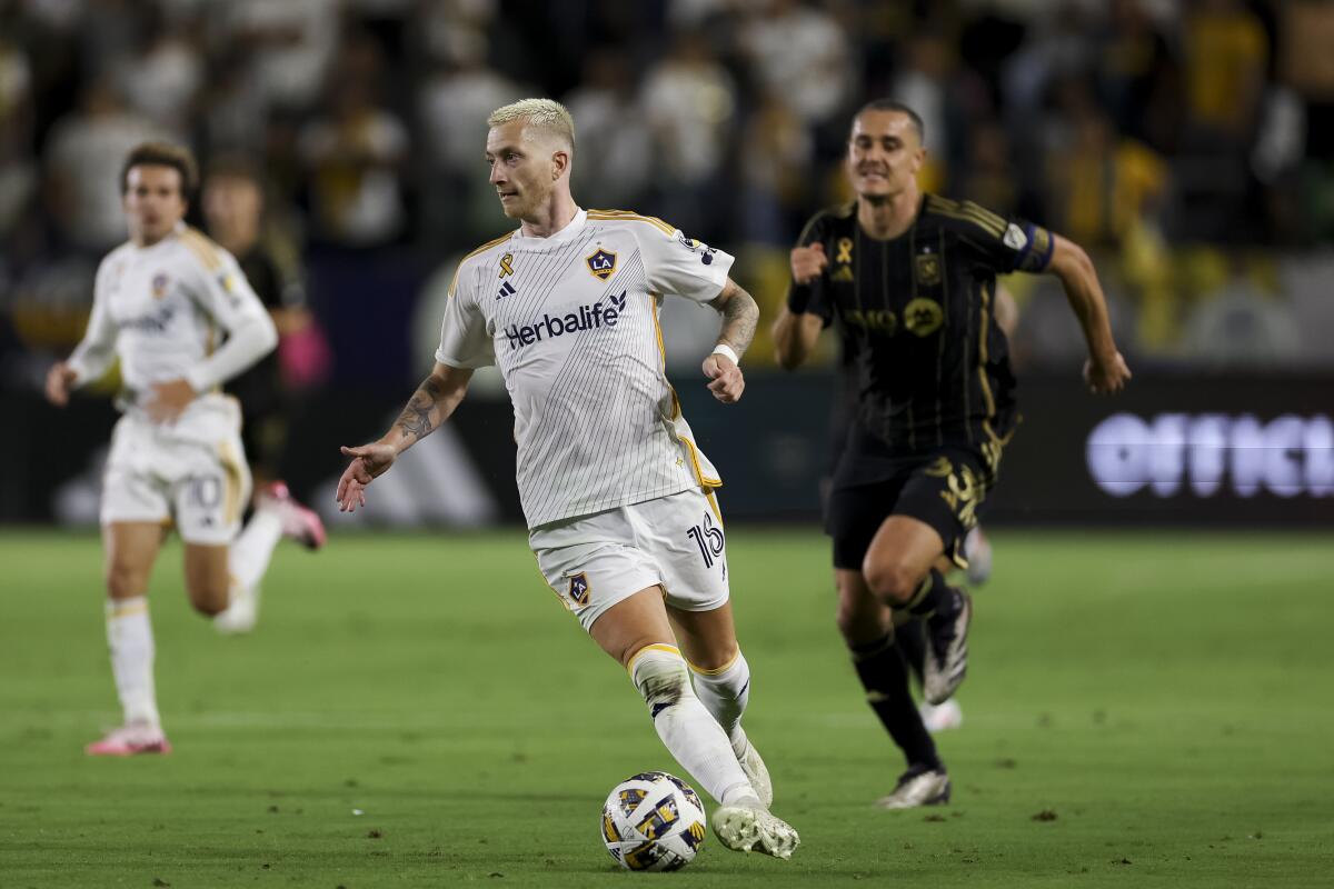 Galaxy forward Marco Reus controls the ball ahead of LAFC defender Aaron Long during a match on Sept. 14.