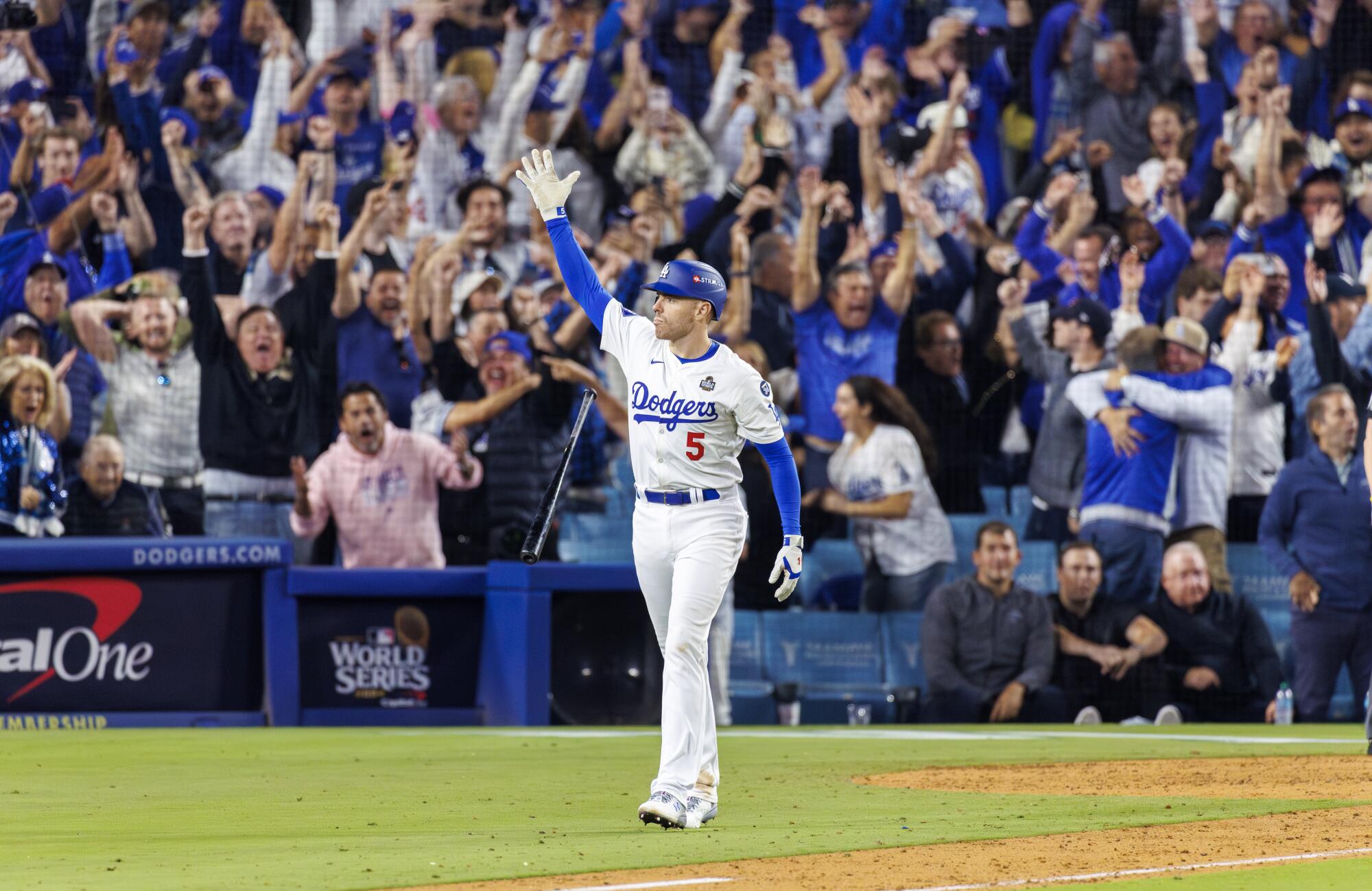 Fans cheer as Freddie Freeman drops his bat after hitting a walk-off grand slam in the 10th inning of Game 1.