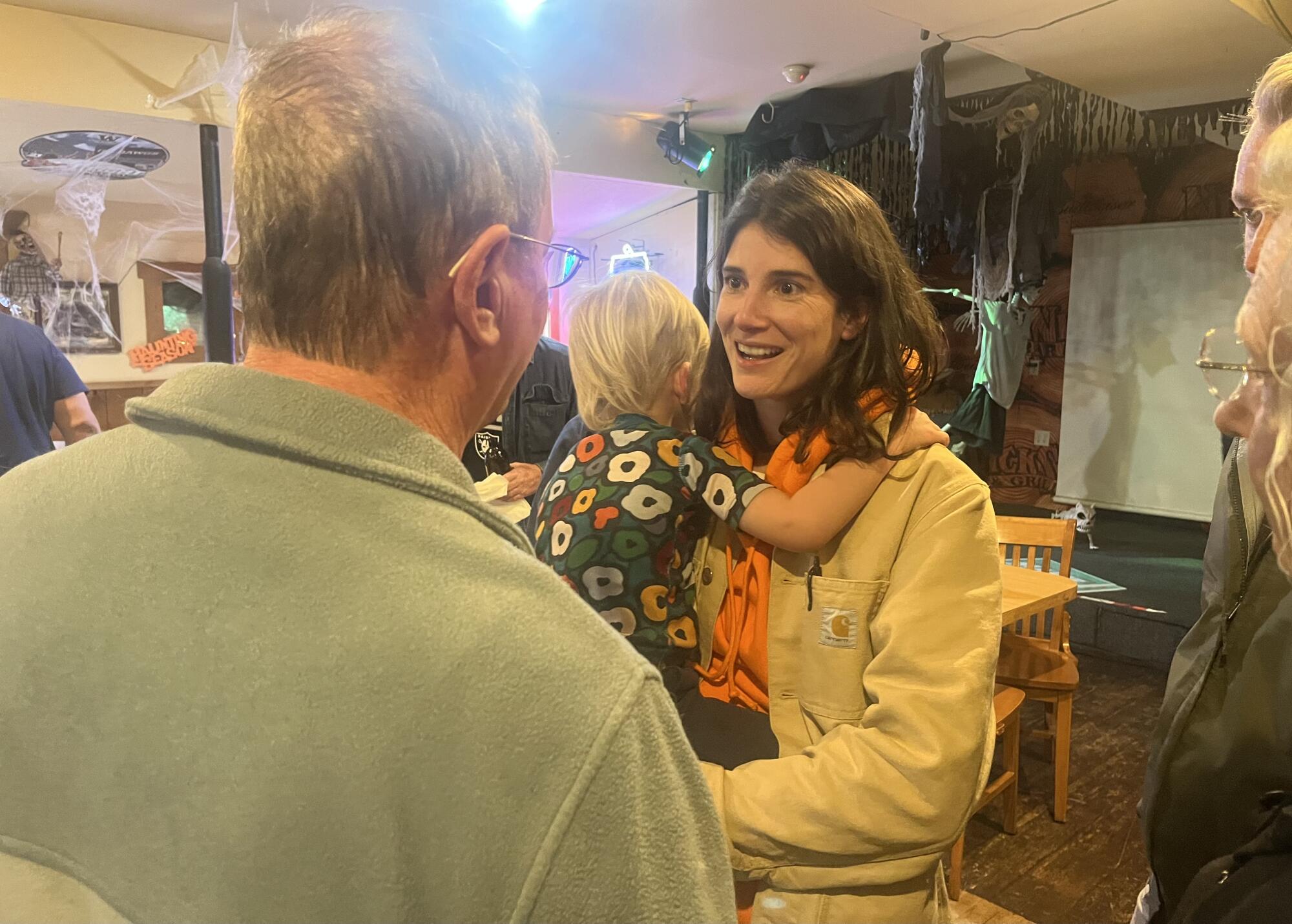 Rep. Marie Gluesenkamp Perez talks to a constituent while holding her child