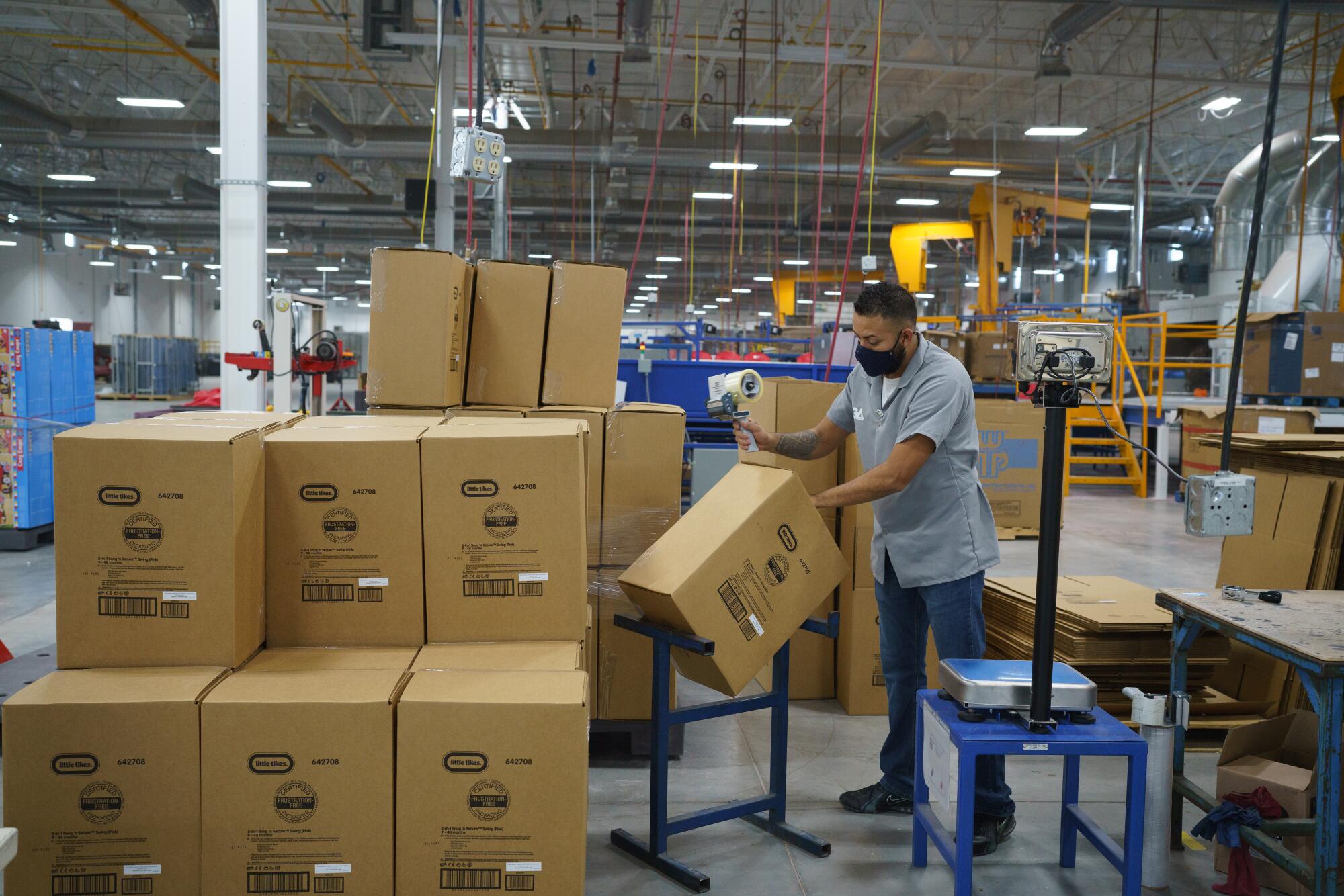 A worker packs boxes at a factory.