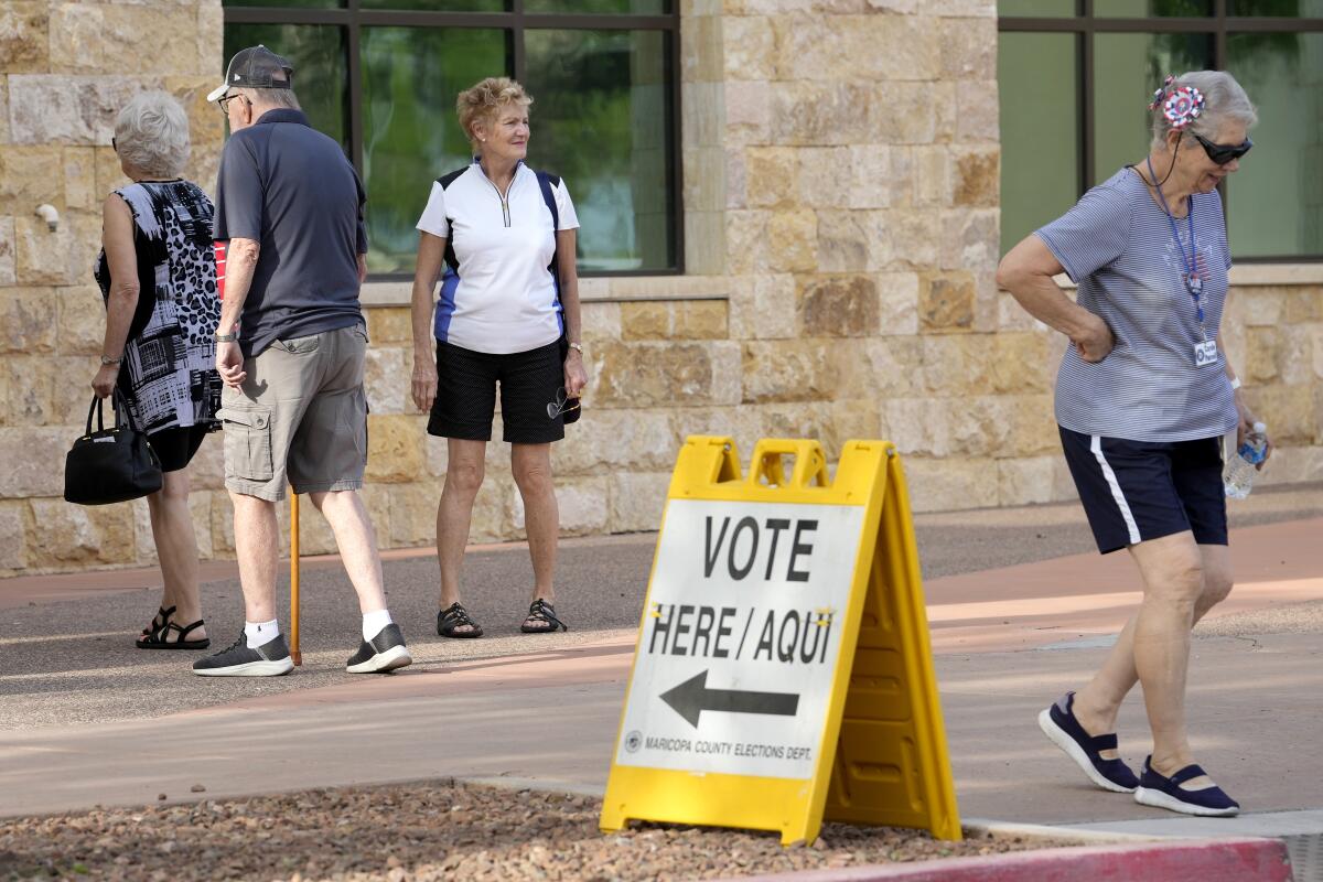 Voters arrive on the first day of early in-person voting at Surprise, Ariz., City Hall on Oct. 9.