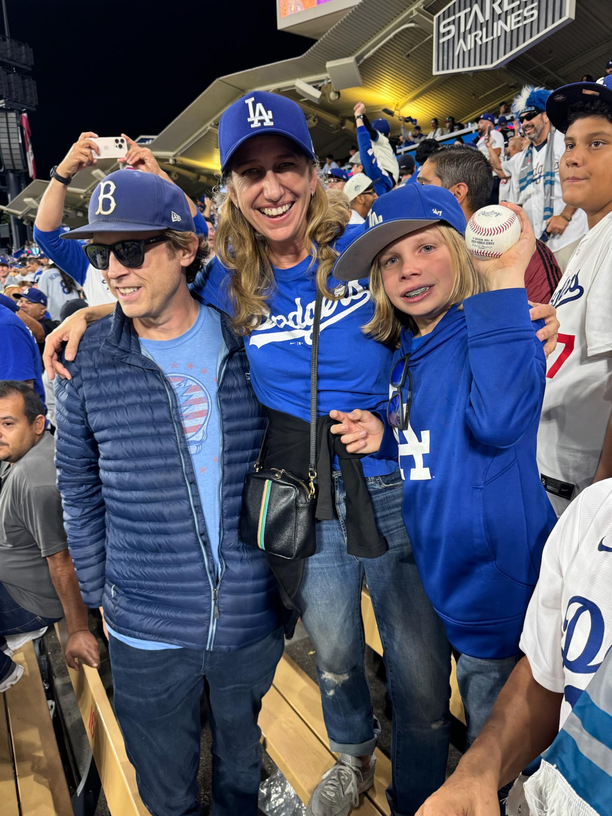 Parents with Zachary, 10, holding Dodgers star Freddie Freeman's walk-off grand slam ball from Game 1 of the World Series. 