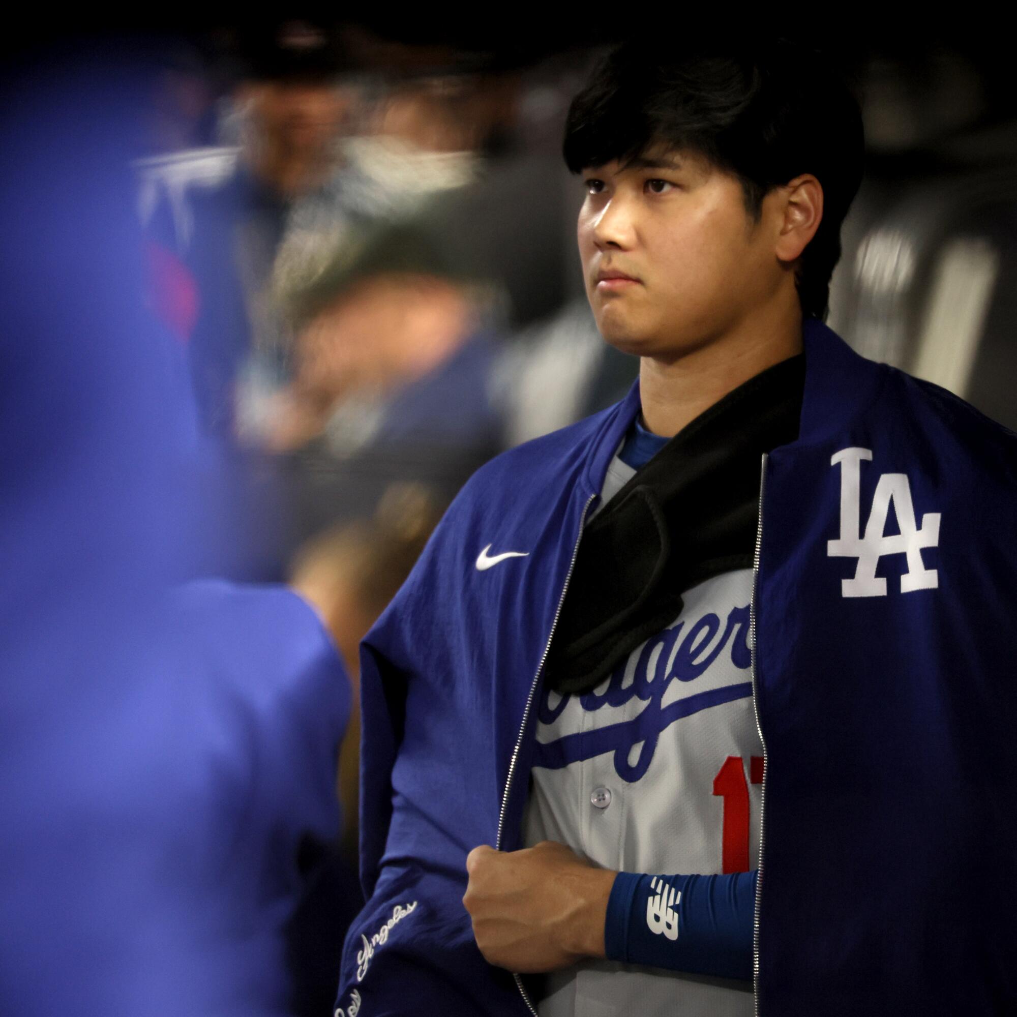 Shohei Ohtani stands in the dugout during the third inning in Game 3 of the World Series.