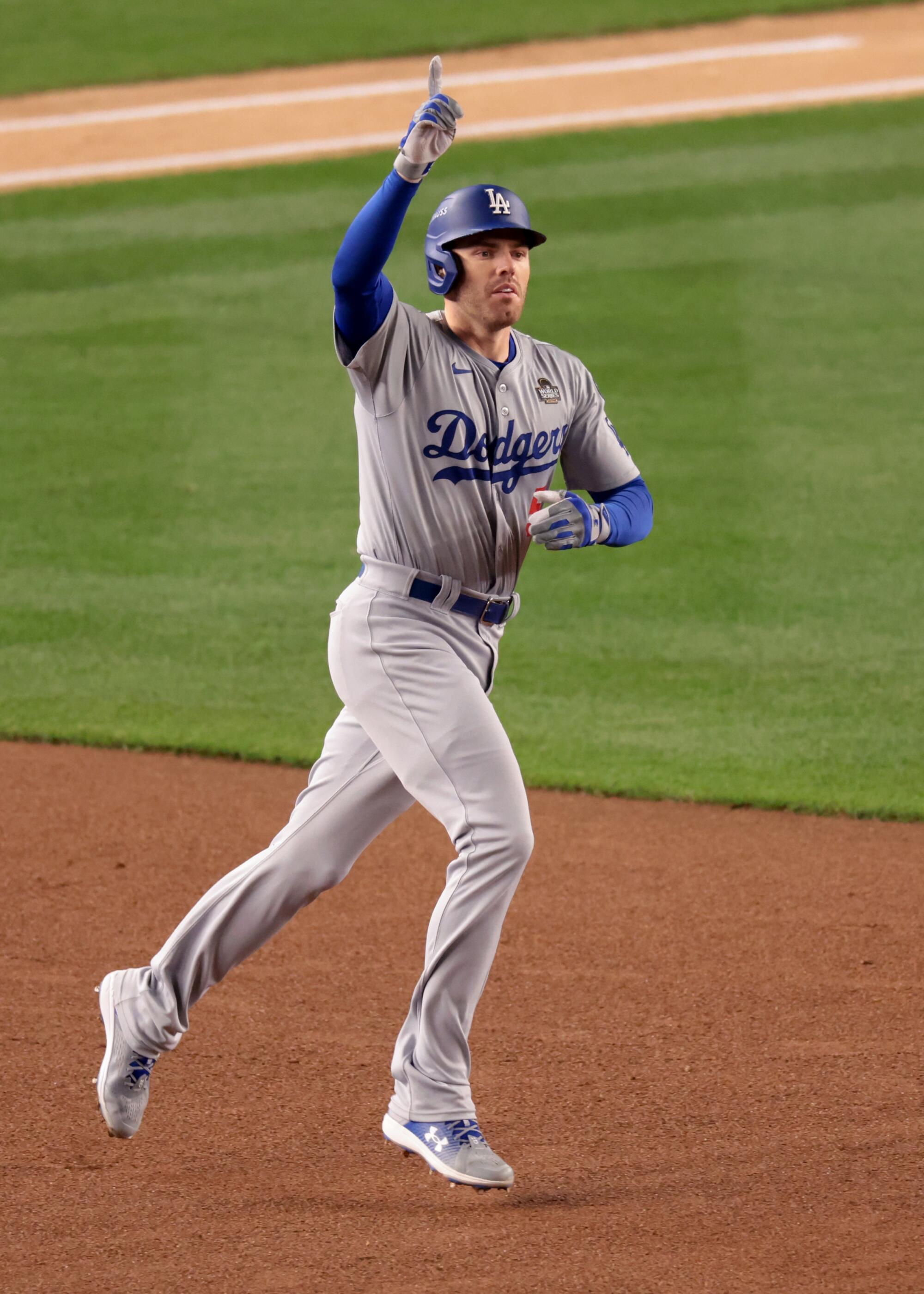 Freddie Freeman raises his index finger as he rounds the bases.