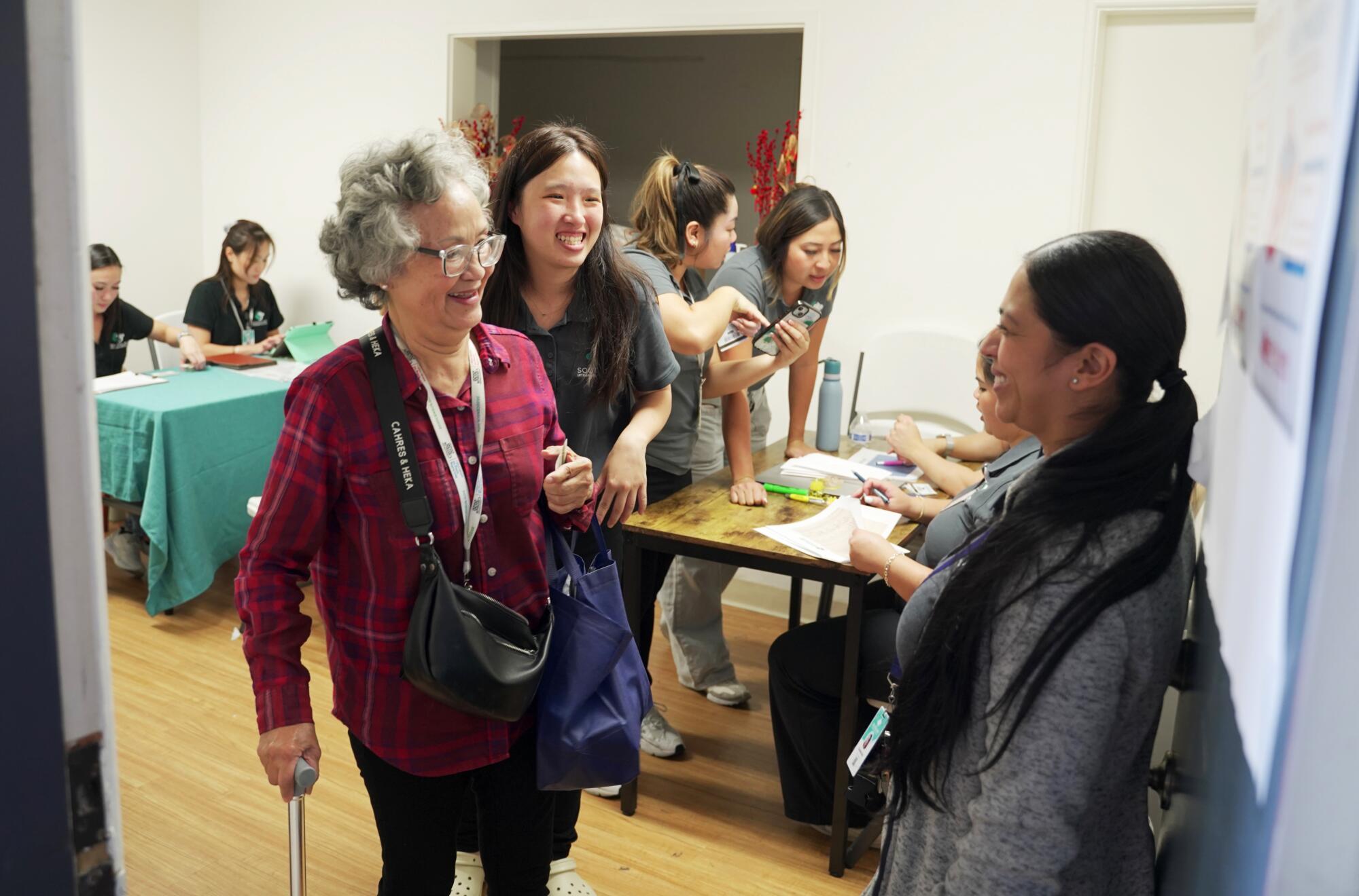 People smile and mingle near information tables.