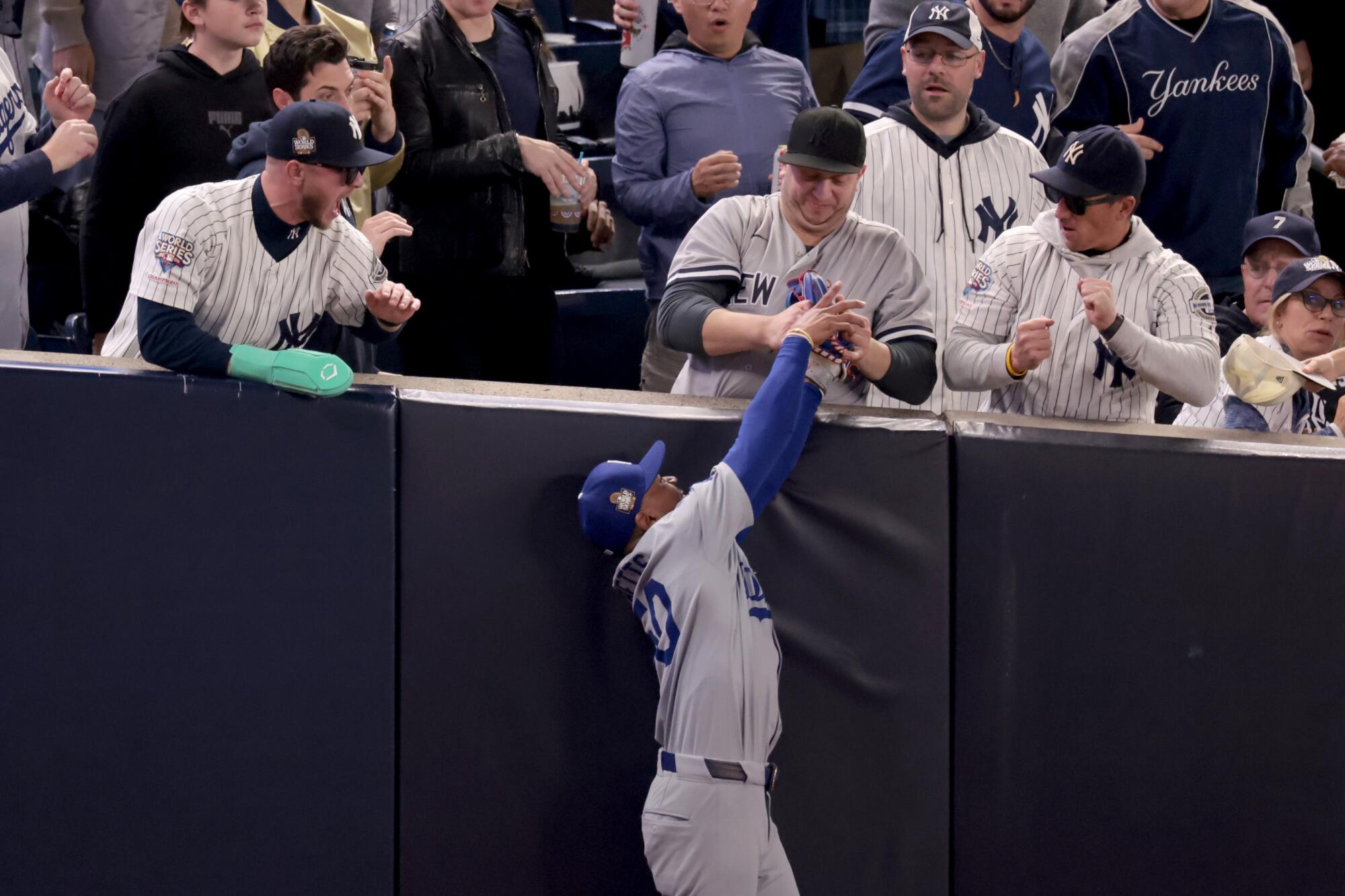 A Yankees fan rips the ball out of Dodgers Mookie Betts' glove in the first inning of Game 4 of the World Series.