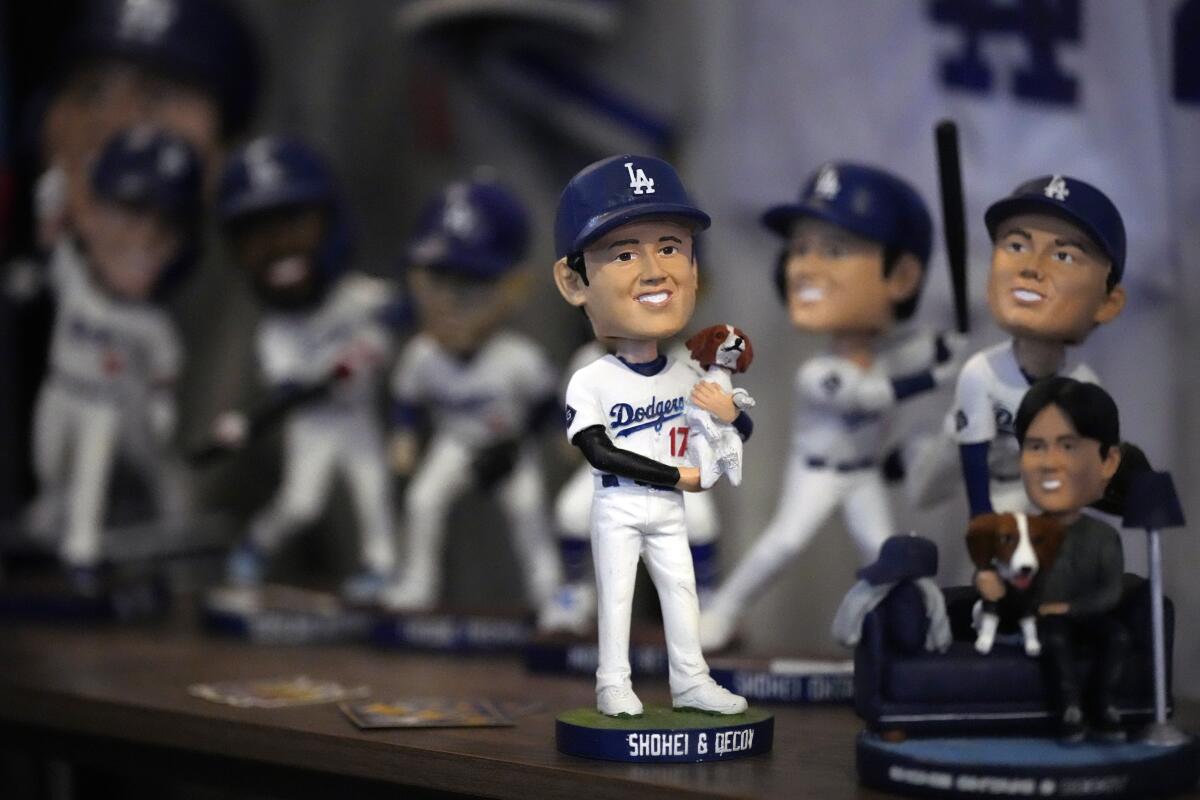 Shohei Ohtani bobbleheads line a shelf. 