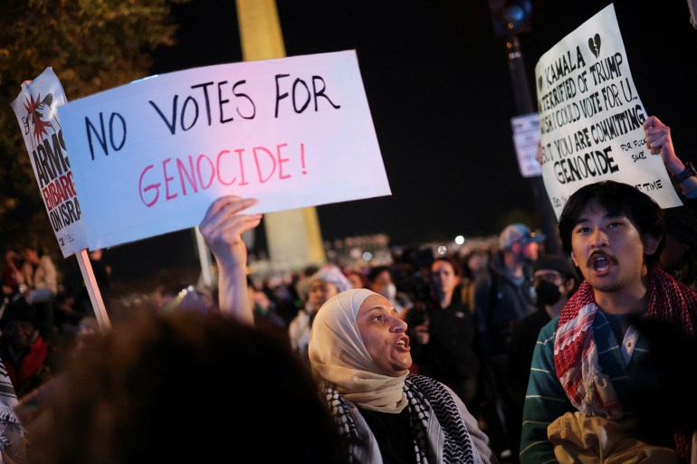 A pro-Palestinian protester holds up a handwritten sign that reads, "No votes for genocide."