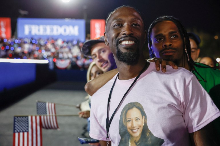 A Kamala Harris supporter wears a pink shirt with her face printed on the front at a Washington DC rally