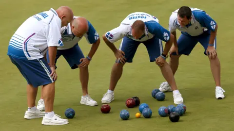 PA Media Scotland's Alex Marshall, Paul Foster, Neil Speirs and David Peacock view a shot against England in the Men's Fours final at Kelvingrove Lawn Bowls Centre, during the 2014 Commonwealth Games in Glasgow.