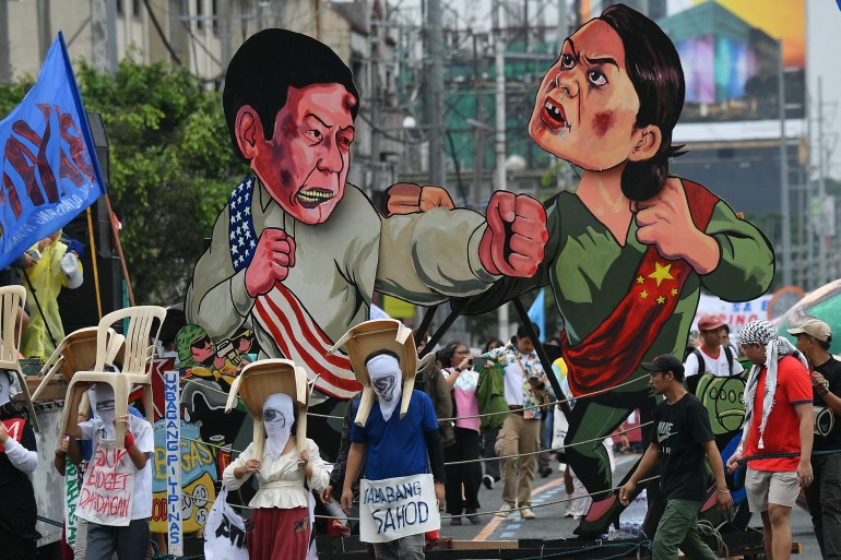 Protesters carrying effigies of Ferdinand Marcos Jr and Sara Duterte fighting