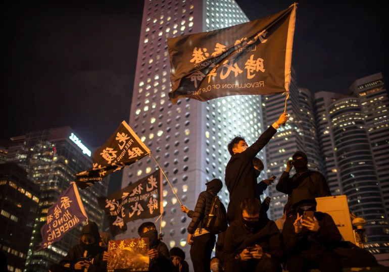 A protestor holds a flag that reads: "Liberate Hong Kong, Revolution of Our Times"