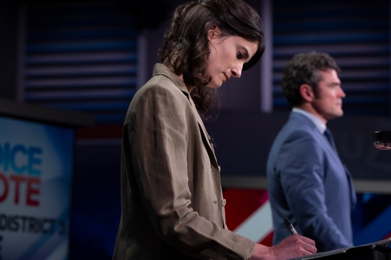 Marie Gluesenkamp Pérez looks downward at her podium as she prepares to debate her rival Joe Kent 