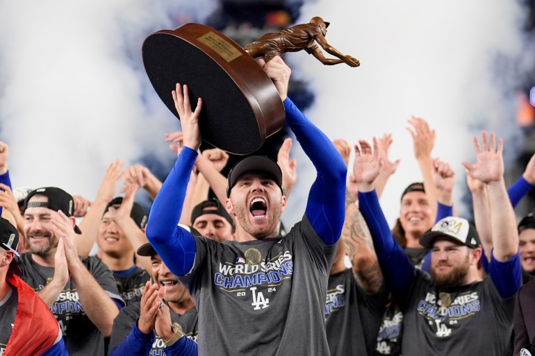 Los Angeles Dodgers' Freddie Freeman celebrates with the MVP trophy after their win against the New York Yankees in Game 5 to win the baseball World Series, Thursday, Oct. 31, 2024, in New York. (AP Photo/Ashley Landis)