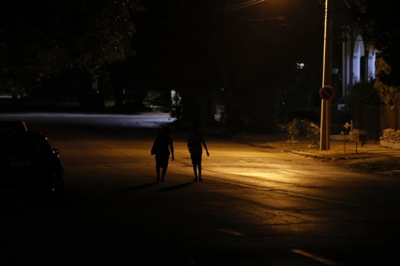 People walk along a dimly lit street in Havana, Cuba in May. Power blackouts have prompted concerns about the government's plan to enhance the electrical system, which failed again over the weekend. Photo by Ernesto Mastrascusa/EPA-EFE