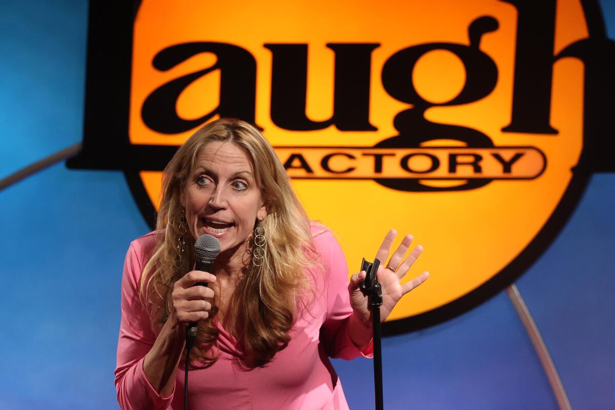 Female comedian holding a mic at the Laugh Factory