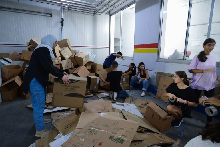 In Beirut’s Ramlet al-Bayda neighbourhood, a group of students prepare boxes of aid for the displaced, Sept 27, 2024 [Lina Malers/Al Jazeera]