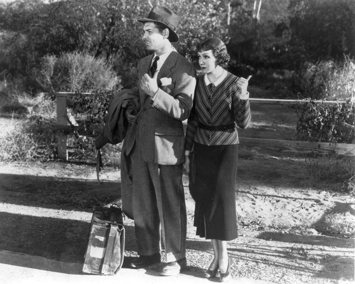 A man and a woman attempting to hitchhike