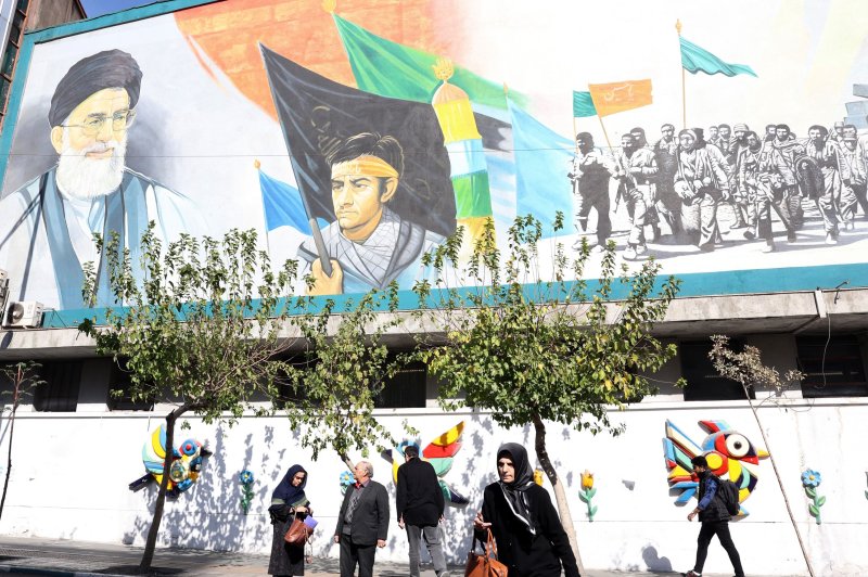 Iranians walk past a wall painting of Supreme Leader Ayatollah Ali Khamenei in Tehran, Iran, on Saturday. Israel Defense Forces confirmed it conducted precise strikes on military targets in Iran. Photo by Abedin Taherkenare/EPA-EFE