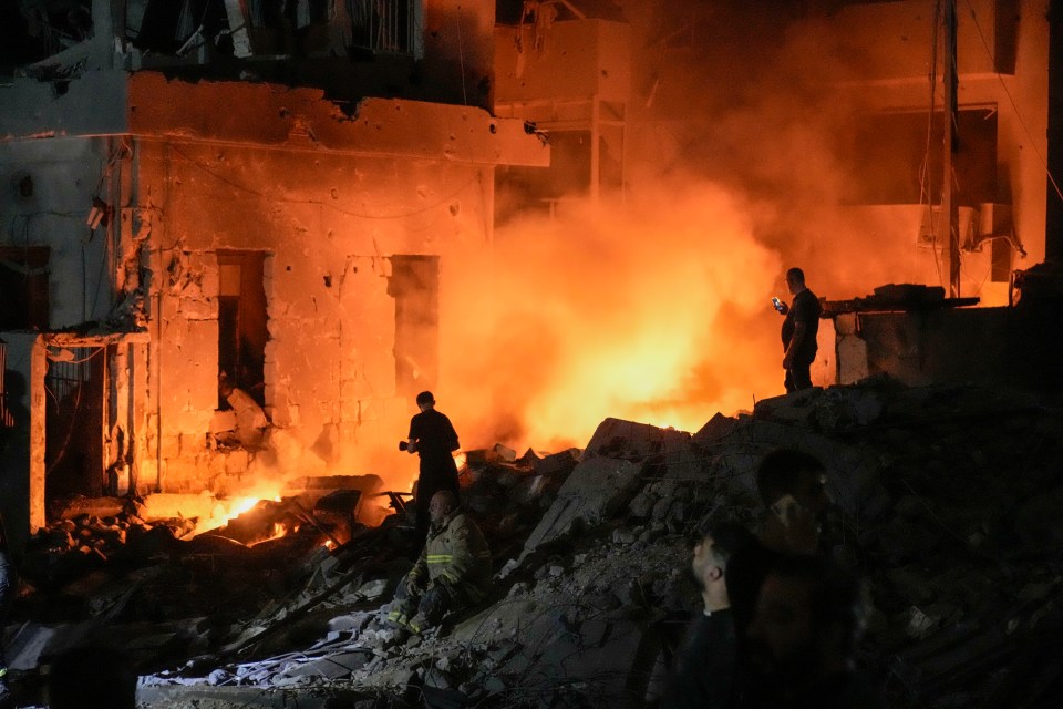 Flames and smoke rise at the scene of destroyed buildings hit by an Israeli airstrike in central Beirut on 10 October