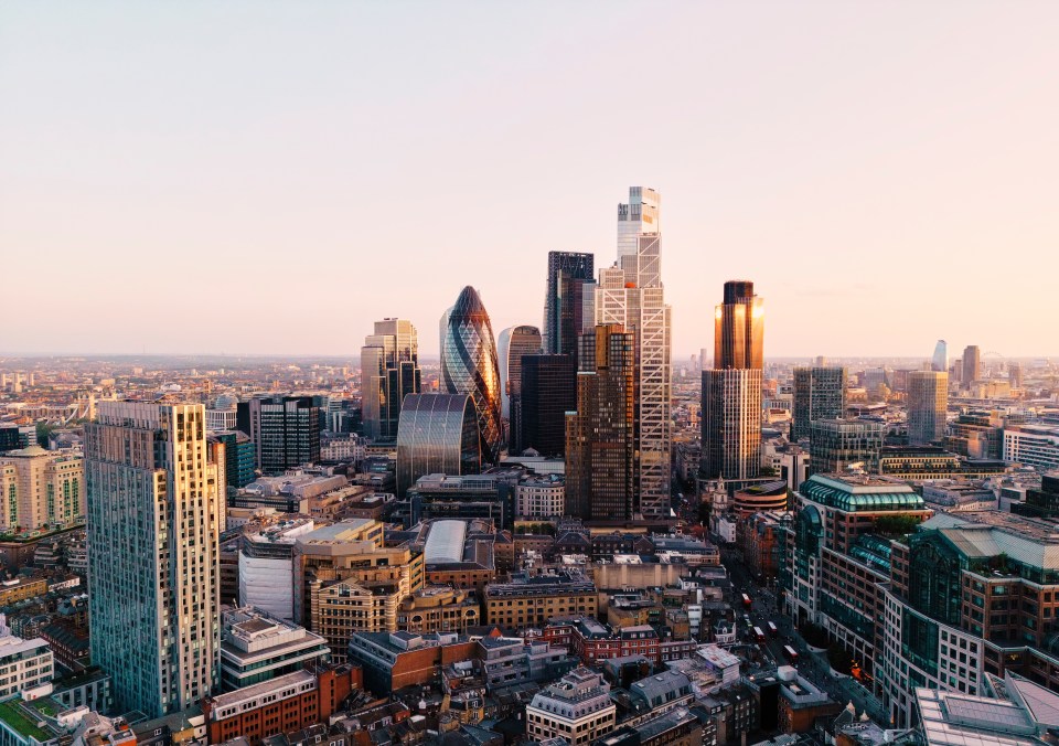 UK, London, elevated view over city financial district skyline at sunset