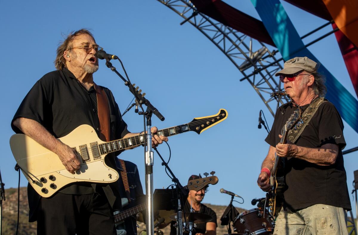 Two older musicians playing guitar onstage