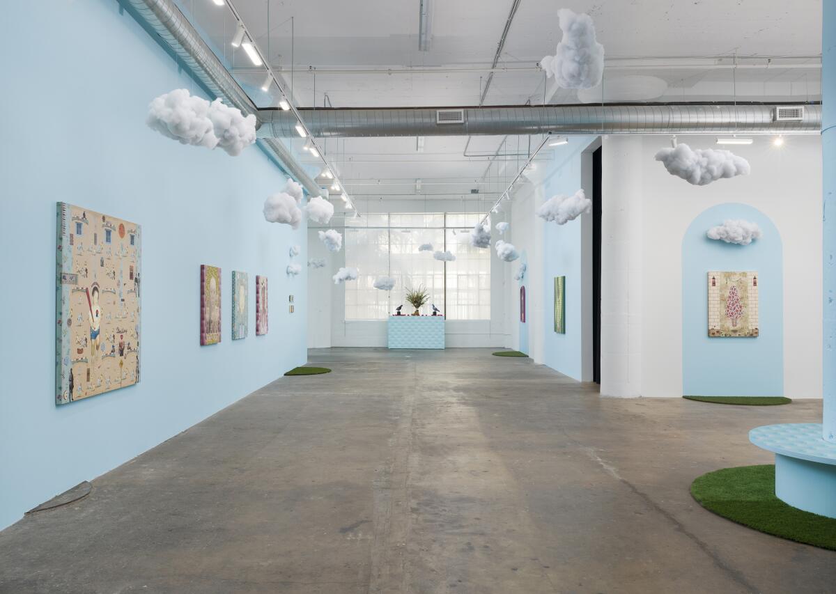 Exhibition view of "Thinking Out Loud" at Vielmetter Los Angeles, with art on pale blue walls and fluffy clouds hanging down