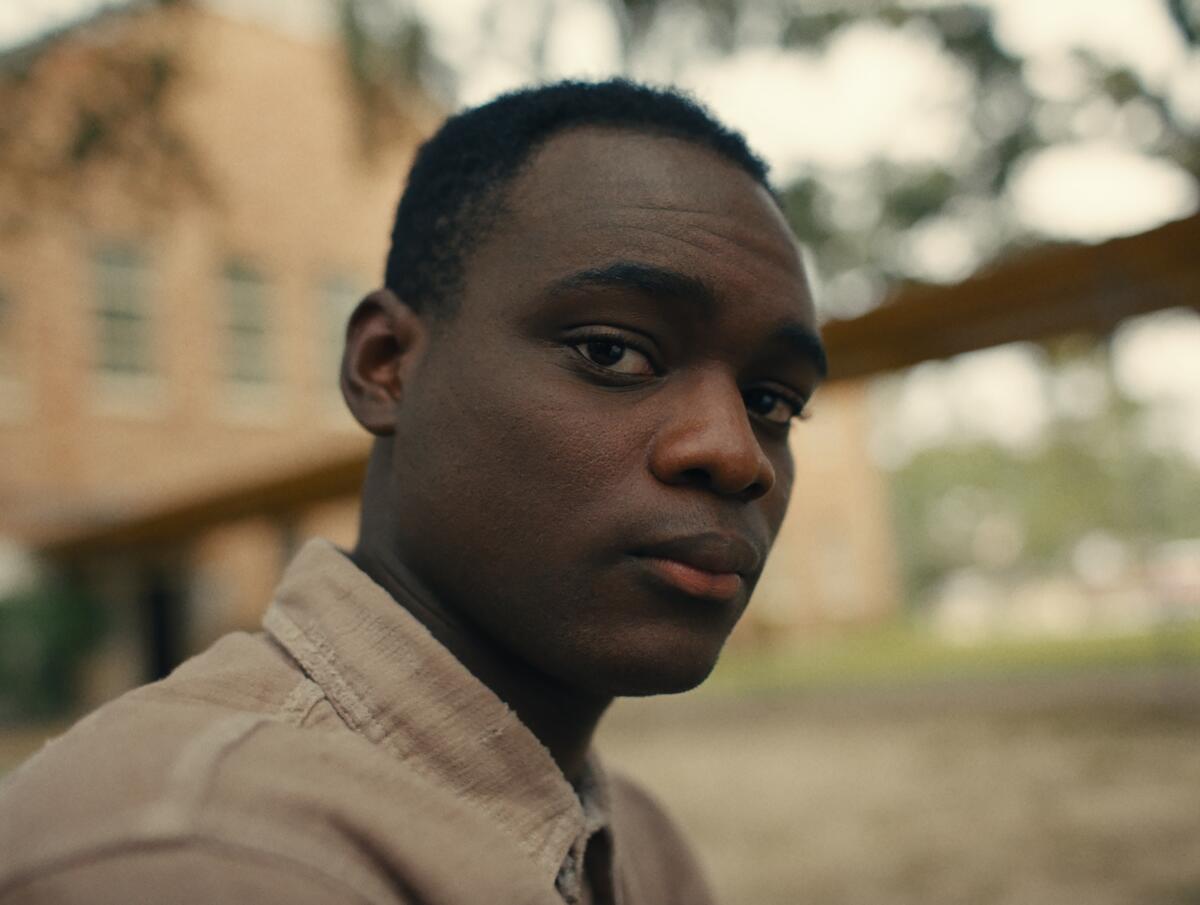 A young man looks warily into the lens.