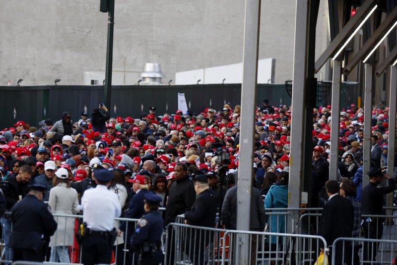 A large crowd of supporters hold flags and wear Trump campaign hats as they wait to enter President Donald J. Trump's rally at Madison Square Garden in New York City on Sunday, Photo by John Angelillo/UPI