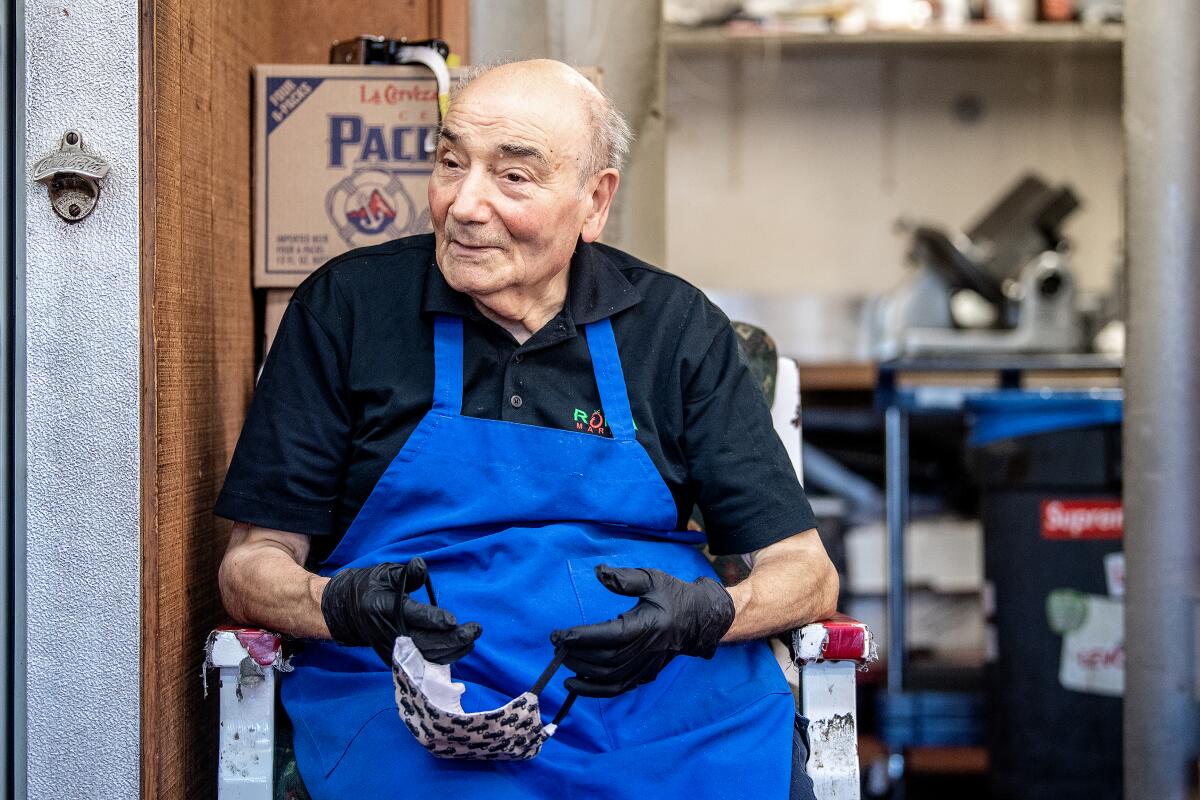 Roma Market owner Rosario Mazzeo sits in a chair 