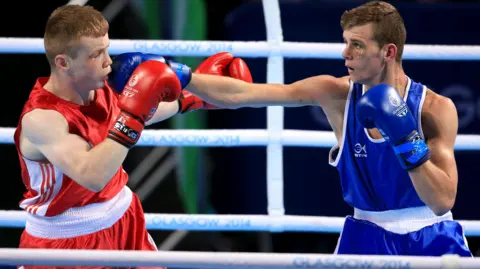 PA Media Scotland's Charlie Flynn (right) and Northern Ireland's Joe Fitzpatrick during the Men's Light (60kg) Final Bout at the SSE Hydro, during the 2014 Commonwealth Games in Glasgow.